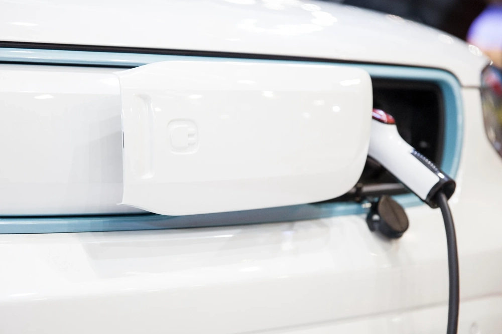 Przewód ładowarki samochodowej podłączony do portu auta elektrycznego